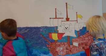 Två barn målar en båt